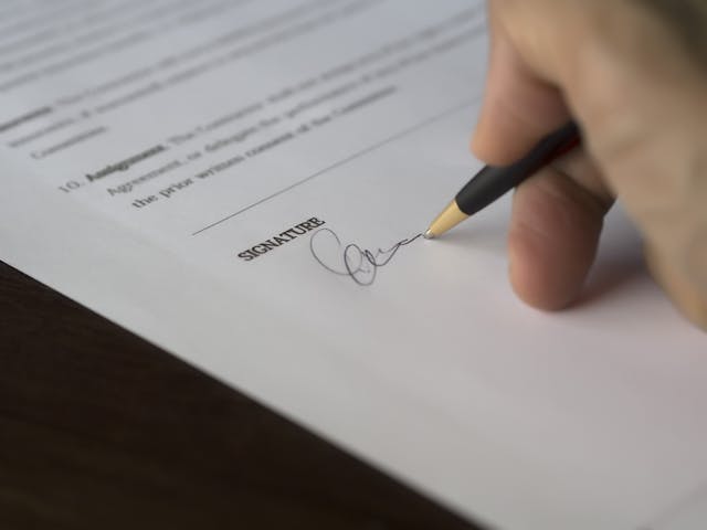 a person signing a paper