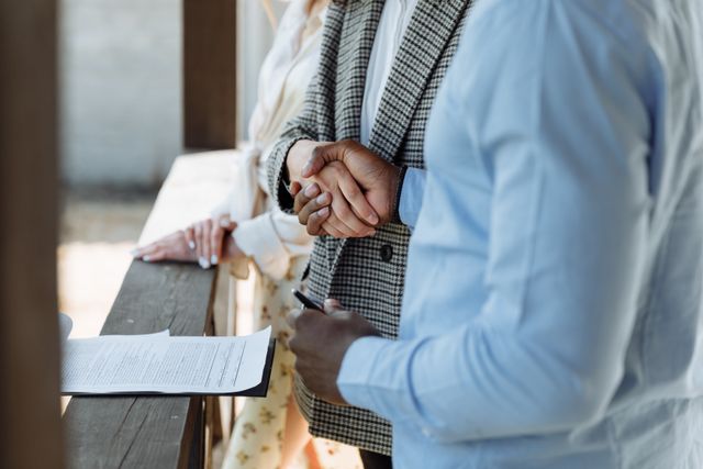 people shaking hands over a document