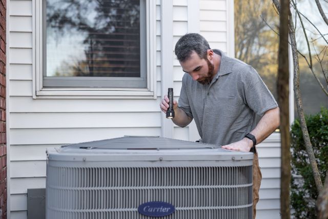 person outside inspecting an HVAC unit