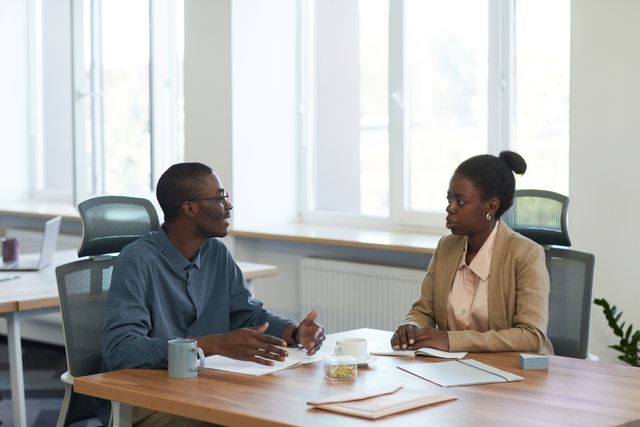 two people seated at a table having a conversation